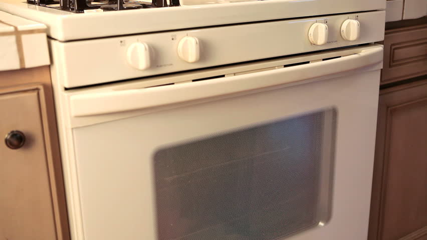 pulling cookies out of the oven