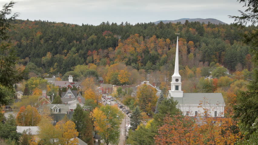 A main street of Stowe, Vermont in Autumn, including its landmark church, from above.