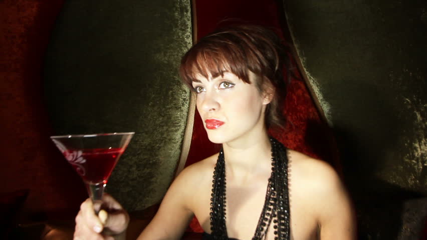 beautiful classic pinup girl in a VIP club drinking a cocktail