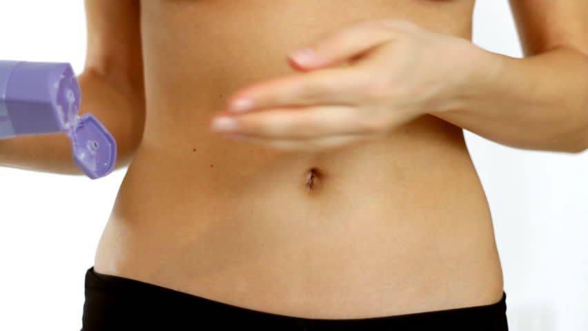 Woman applies body lotion to her belly