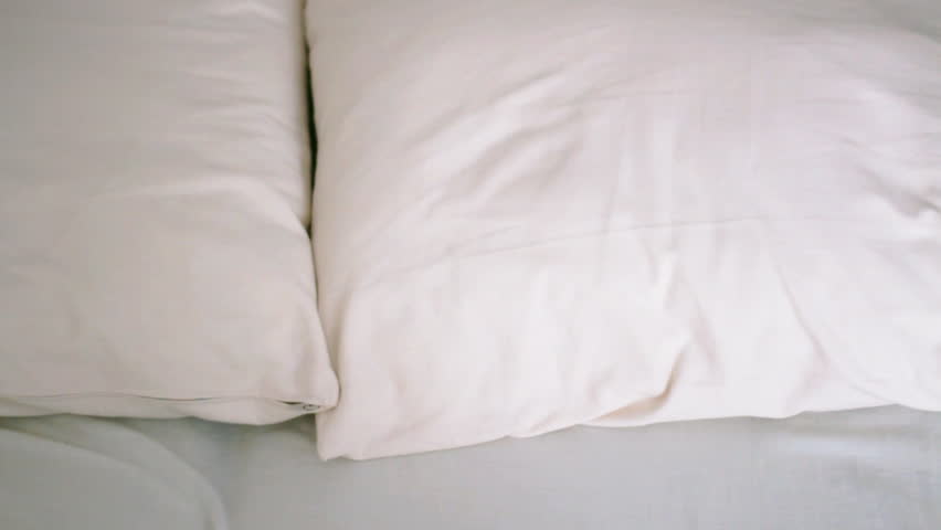 Woman falling backward onto bed, slow motion 