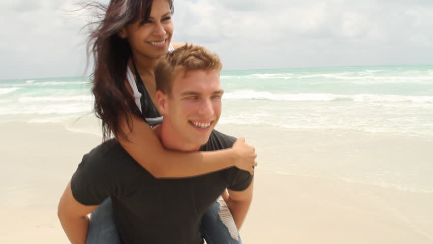 Young woman riding on young man's back