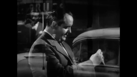 CIRCA 1950s - A salesman at a car dealership is friendly with a customer and workers in 1951.