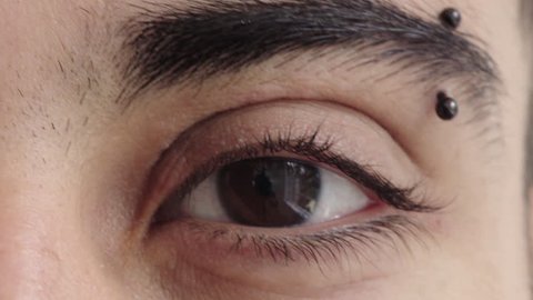 Close Up Of Hispanic Man Eye Looking At Camera Wearing Eyebrow Piercing Reflection On Iris Macro Beauty Shot