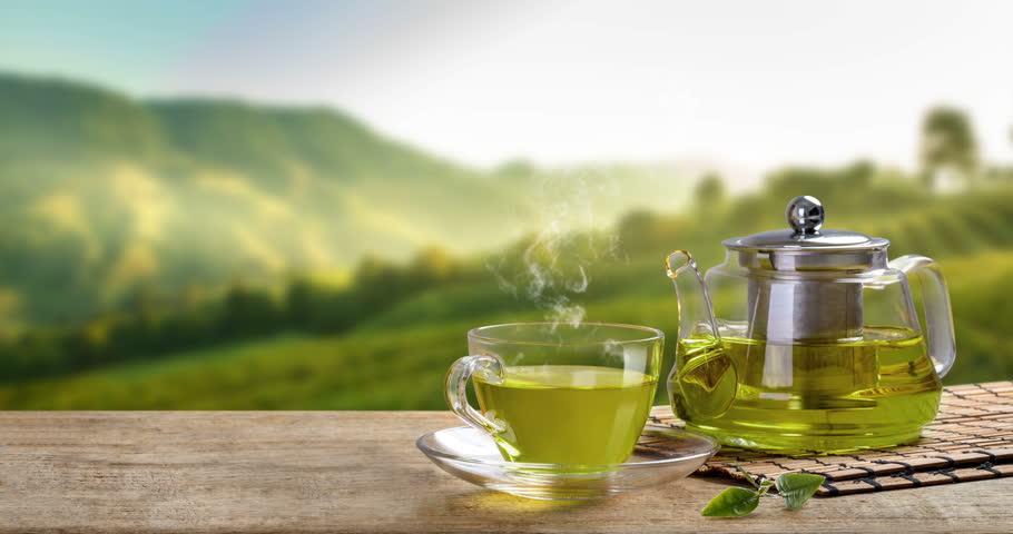 Warm cup. Чайная плантация фон. Warm Cup of Tea and Leaf on Wooden Table with the Tea Plantations.