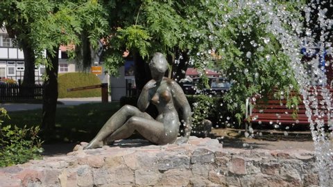 Nude Asian Gardening - Nida / lithuania - 06 08 2019: stone statue of a naked woman near a  fountain.