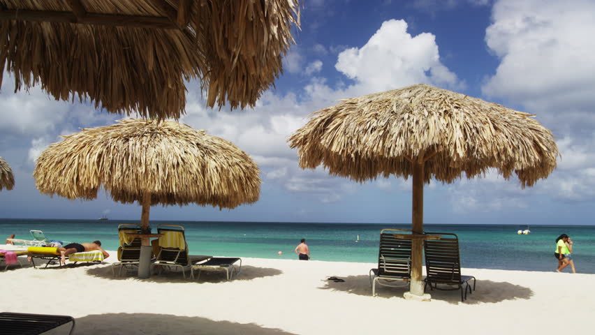 Tropical Beach With Palm Trees Umbrella And Chairs Hot Summer Native Thached Beach Huts On The Eagle 4k Stock Footage Clip