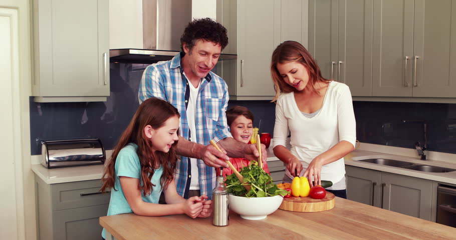 Happy family preparing salad together in the… - Royalty Free Video