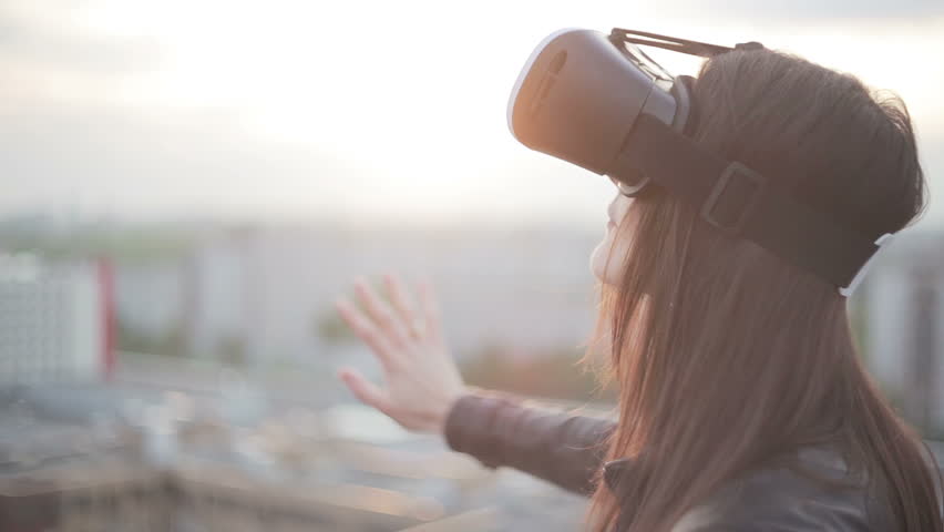 woman uses a virtual reality glasses on the roof