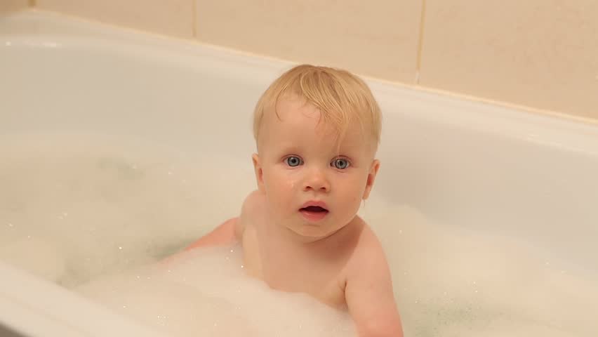 A Cute Little Boy Taking Hot Bath In Bathtub And Playing With Baby Smiles And Laughs When He Playing With Toys In A White Bubble Bath Caucasian