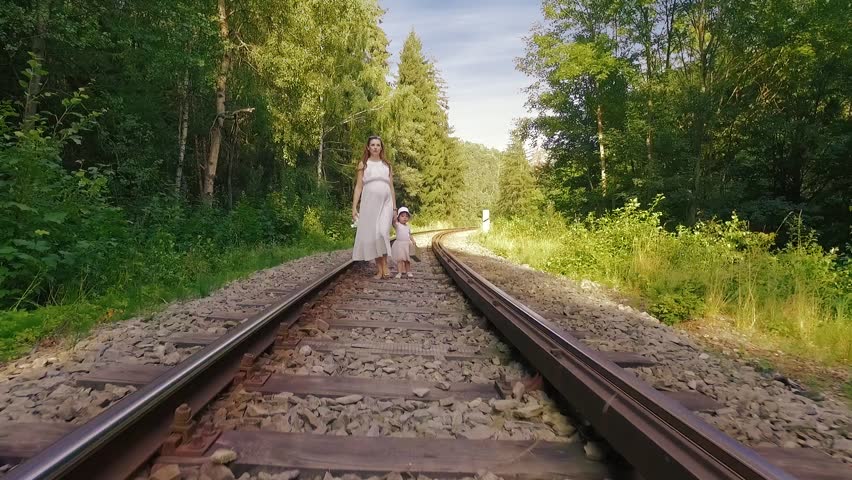 A Beautiful Latina Brunette Walks Away From The Camera Down A Lonely Stretch Of Railroad Track