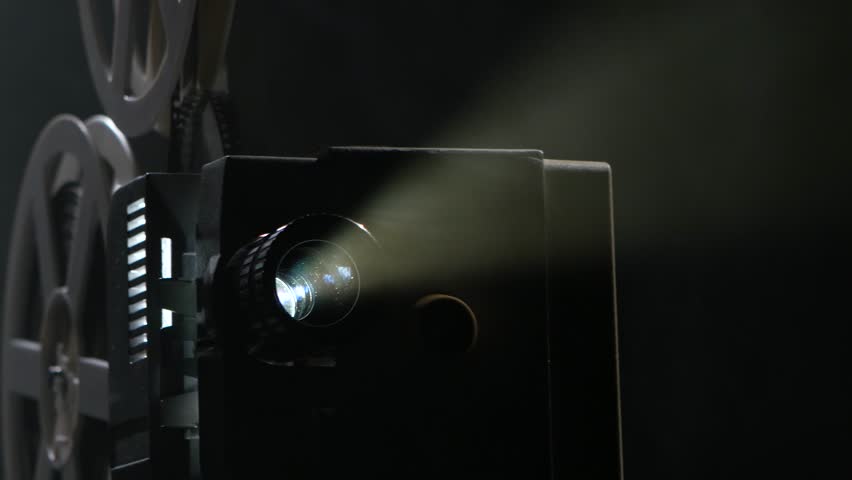 A Motion Picture Movie Projector Sends A Beam Of Light Into The Dark ...