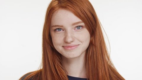 Close footage of young Caucasian red haired teenage girl smiling laughing on white background