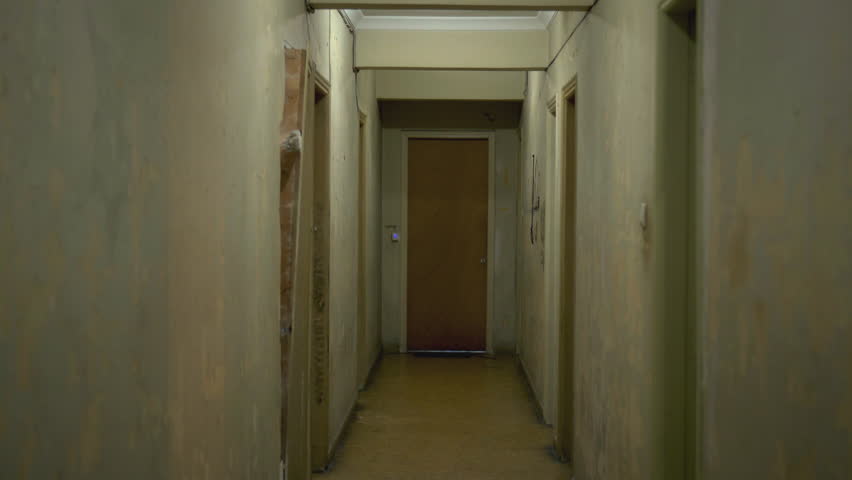 Apartment Building Hallway walking inside a long dark hallway of an old apartment building Apartment Building Hallway walking inside a long dark hallway of an old apartment building