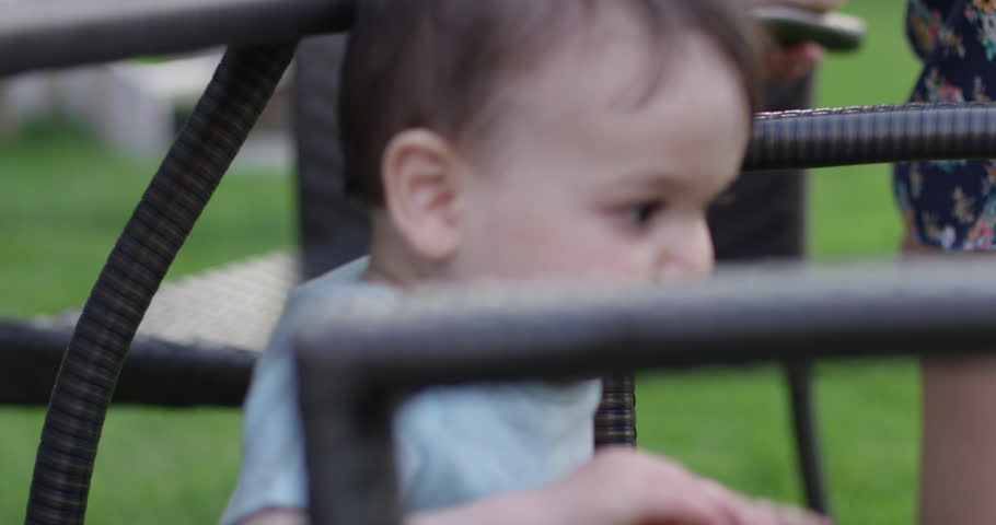 Toddler Boy Plays On Patio Furniture