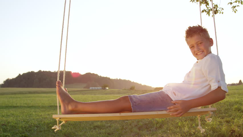 Stock Video Clip Of SLOW MOTION CLOSEUP Smiling Young Boy Swings