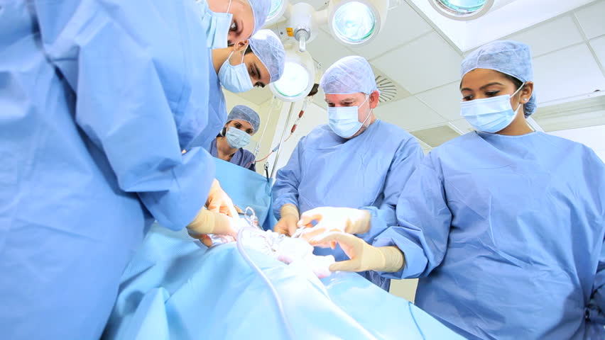 Senior Doctor Performing Operation Using Surgical Equipment Helped By ...