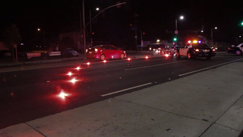 Cars Passing Road Flares And Police Cruiser With Flashing Siren Lights ...