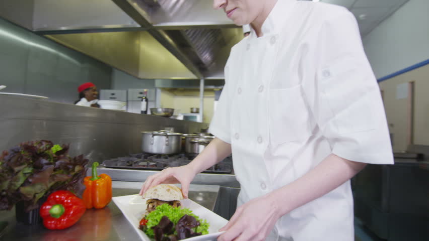 Restaurant Kitchen Video waitress collects her order from the chef in a busy hotel or Restaurant Kitchen Video waitress collects her order from the chef in a busy hotel or