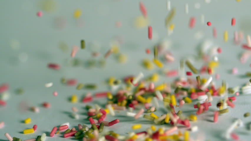 Sprinkles Falling Onto Blue Surface In Slow Motion Stock Footage Video ...