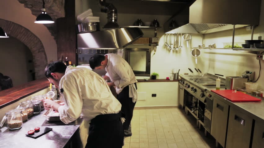 Restaurant Kitchen Chefs couple of male chefs clean the steel table and in restaurant Restaurant Kitchen Chefs couple of male chefs clean the steel table and in restaurant