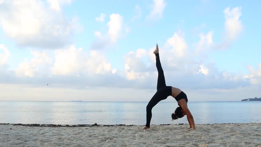 Stock Video Clip Of Young Woman Practicing Yoga At The Beach Stock Video Clip Of Young Woman Practicing Yoga At The Beach Shutterstock