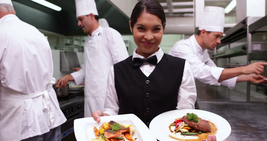 Restaurant Kitchen Staff happy restaurant staff smiling at camera in a commercial kitchen Restaurant Kitchen Staff happy restaurant staff smiling at camera in a commercial kitchen
