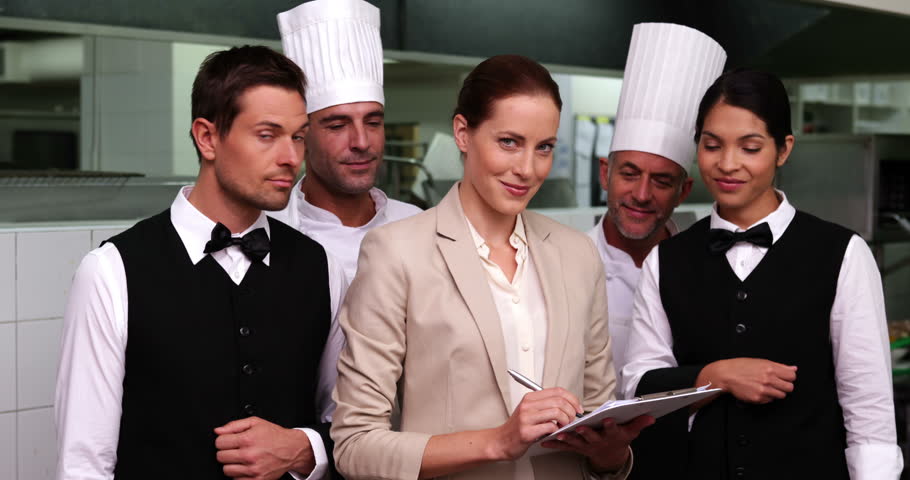 Restaurant Kitchen Staff happy restaurant staff smiling at camera in a commercial kitchen Restaurant Kitchen Staff happy restaurant staff smiling at camera in a commercial kitchen