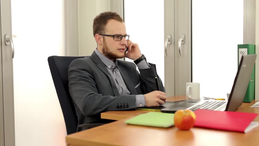 Young, Handsome Men Sitting Behind The Desk And Using Computer, He ...